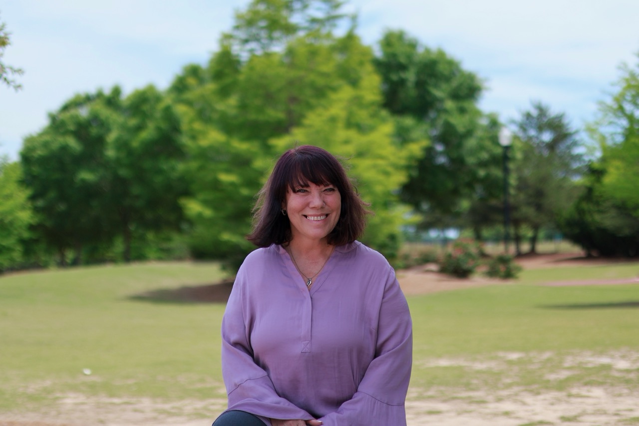 Beth Ali smiling outdoors in a park